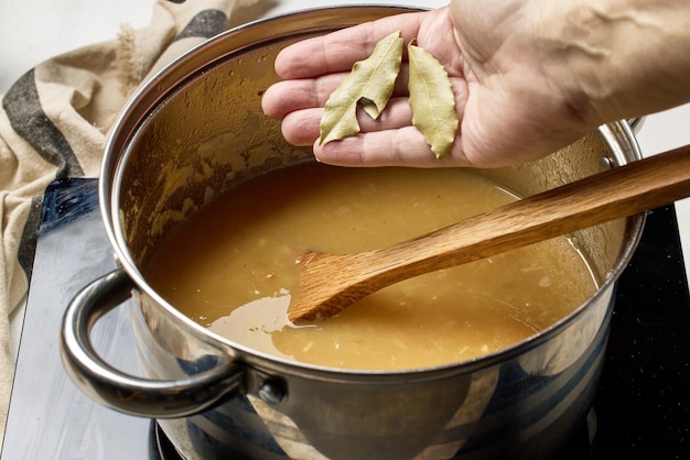 Hand holding wooden spoon over bowl